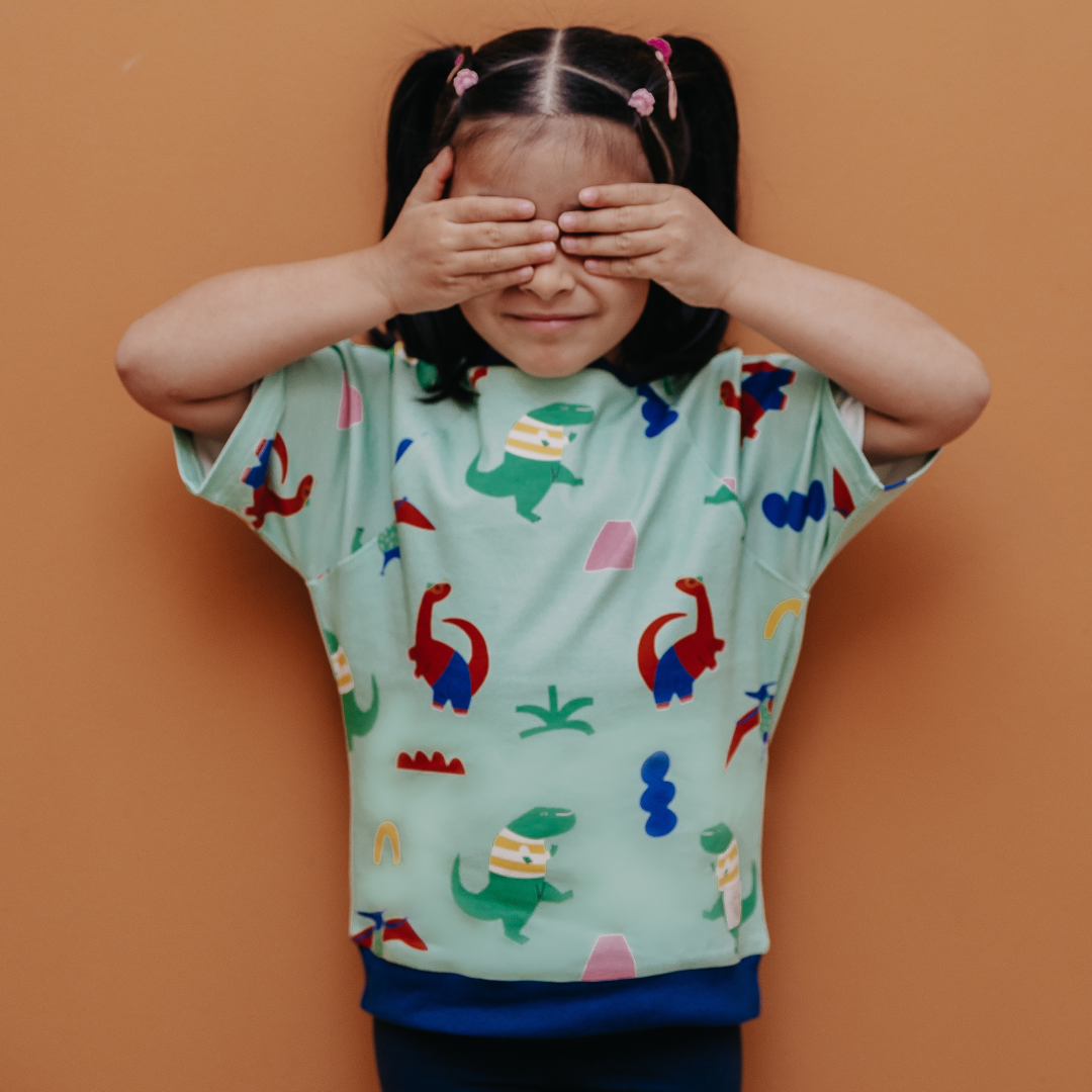 Kurzarm-Shirt im Unisex-Schnitt für Kinder mit dem Dino-Party-Muster von der Marke Oktopulli