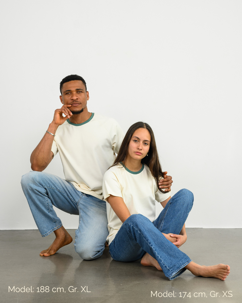 Ein Mann und eine Frau tragen ein Raglan Shirt in Weiß von Oktopulli und sitzen auf dem Boden