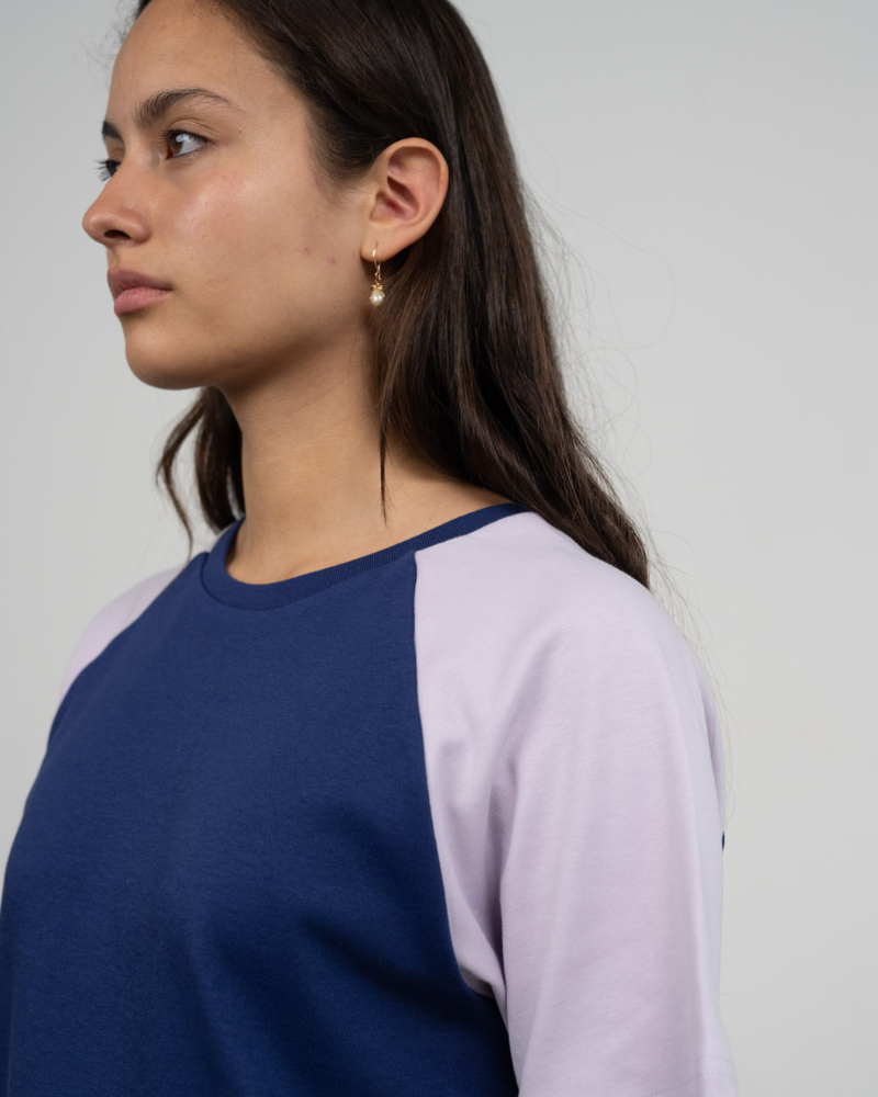 Seitenansicht einer Frau im fairen T-Shirt in Blau und Flieder von Oktopulli mit Unisex Schnitt aus Bio-Baumwolle