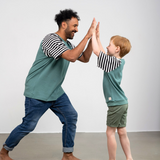 Vater und Sohn klatschen sich in die Hände und tragen dabei das faire Shirt von Oktopulli aus Bio-Baumwolle