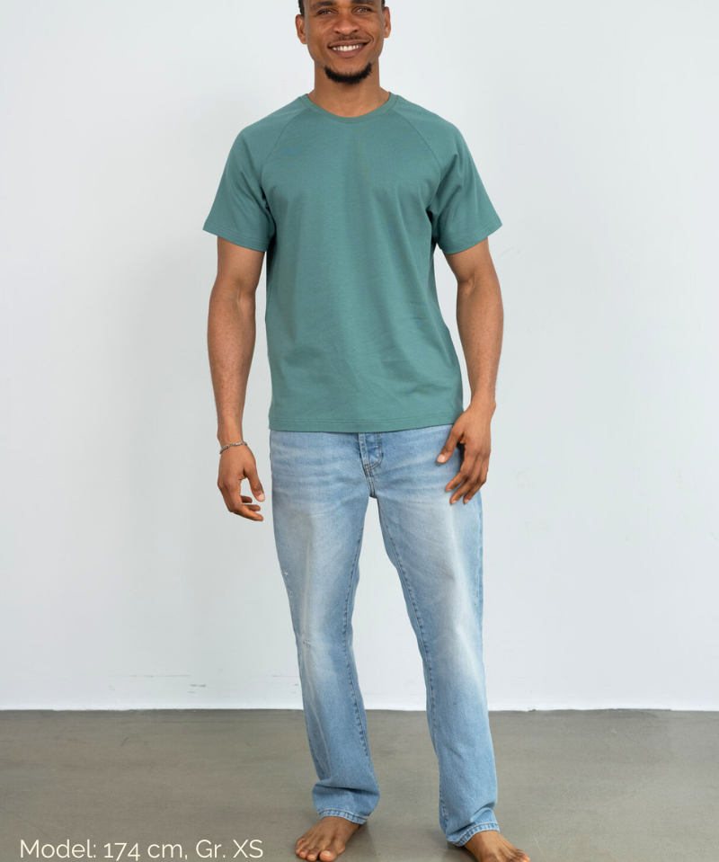 Ein Mann trägt eine Jeans und ein grünes Raglan Shirt der Marke Oktopulli