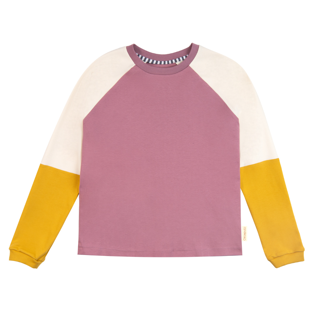 Erwachsenenpulli mit Raglanärmeln Benja in vier Farben. Korpus altrosa. Ärmel zweigeteilt. Obere Farbe creme, untere Farbe gelb. Halsbündchen altrosa. Armbündchen gelb. An den Seitennähten befinden sich kleine Schlitze. 