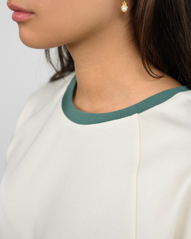 Nahaufnahme des fairen Oktopulli T-Shirts aus Bio-baumwolle in Weiß mit grünem Halsbündchen