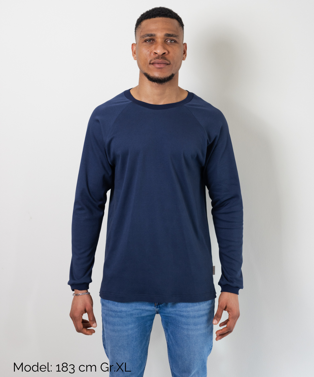 Ein Mann trägt den fairen Alltagsbegleiter für Erwachsene aus Bio-Baumwolle in Blau im Unisex-Schnitt von Oktopulli