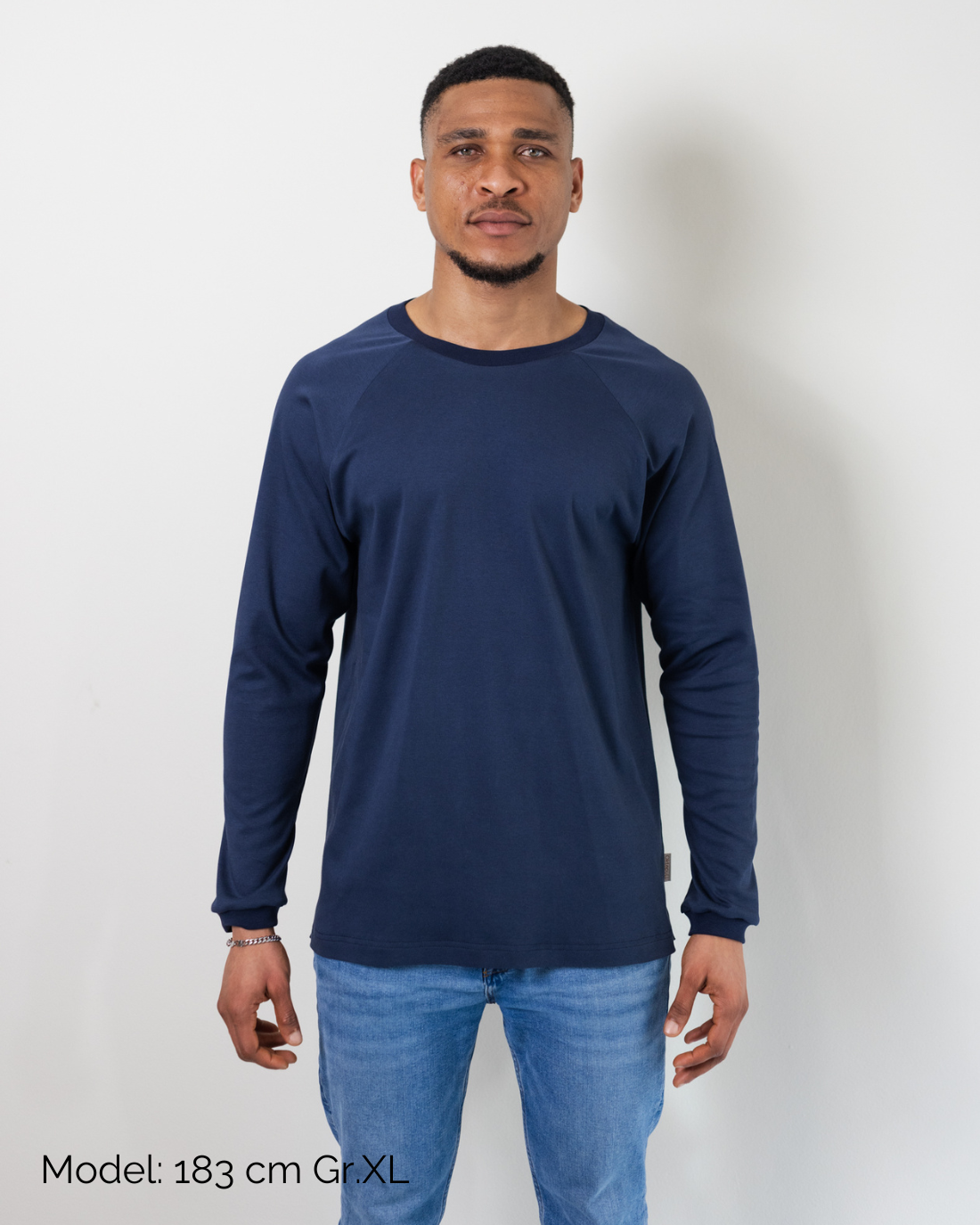 Ein Mann trägt den fairen Alltagsbegleiter für Erwachsene aus Bio-Baumwolle in Blau im Unisex-Schnitt von Oktopulli