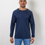 Ein Mann trägt den fairen Alltagsbegleiter für Erwachsene aus Bio-Baumwolle in Blau im Unisex-Schnitt von Oktopulli