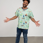 Ein lächelnder Mann trägt das faire Shirt von der Marke Oktopulli mit Dino Motiv