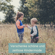 Zwei Kinder stehen auf einer Wiese und reichen sich die Hand. Beide tragen einen Oktopulli.